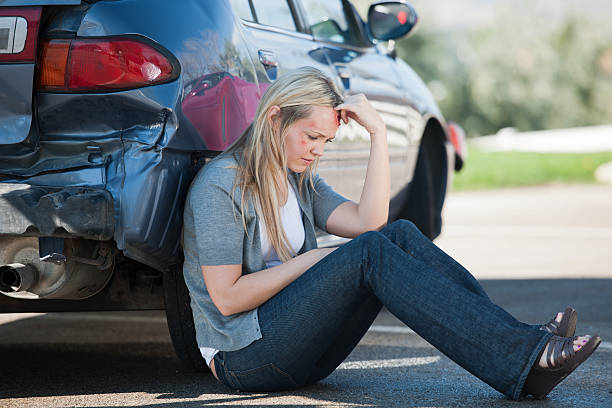 car accident victim sitting by car